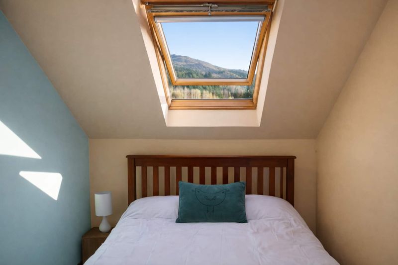 A double bedroom lit by a skylight over the bed